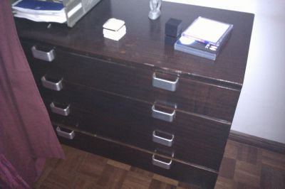 quarto composto por cama cómoda e mesa cabeceira